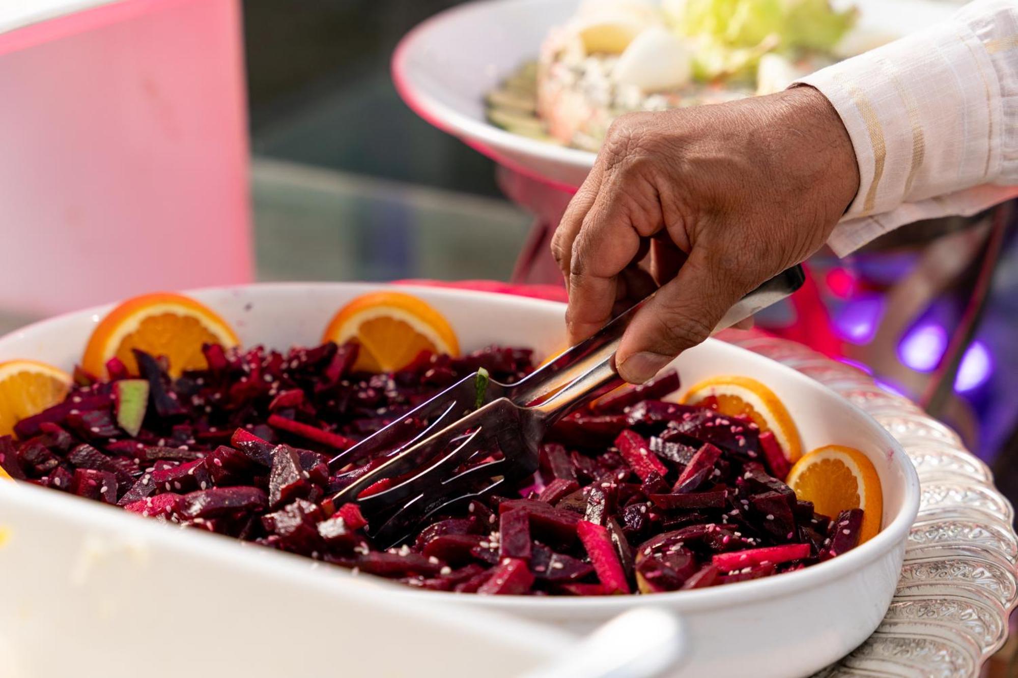 Sheraton Dammam Hotel & Convention Centre Exterior photo A hand using a buffet server to serve food