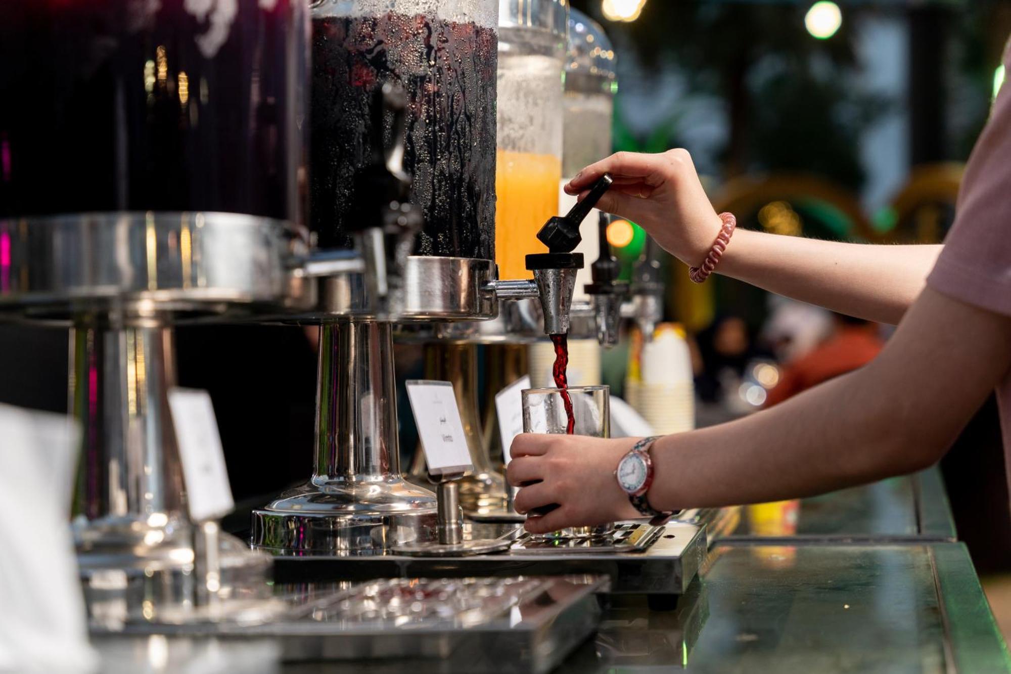 Sheraton Dammam Hotel & Convention Centre Exterior photo A bartender using a tap to serve a drink